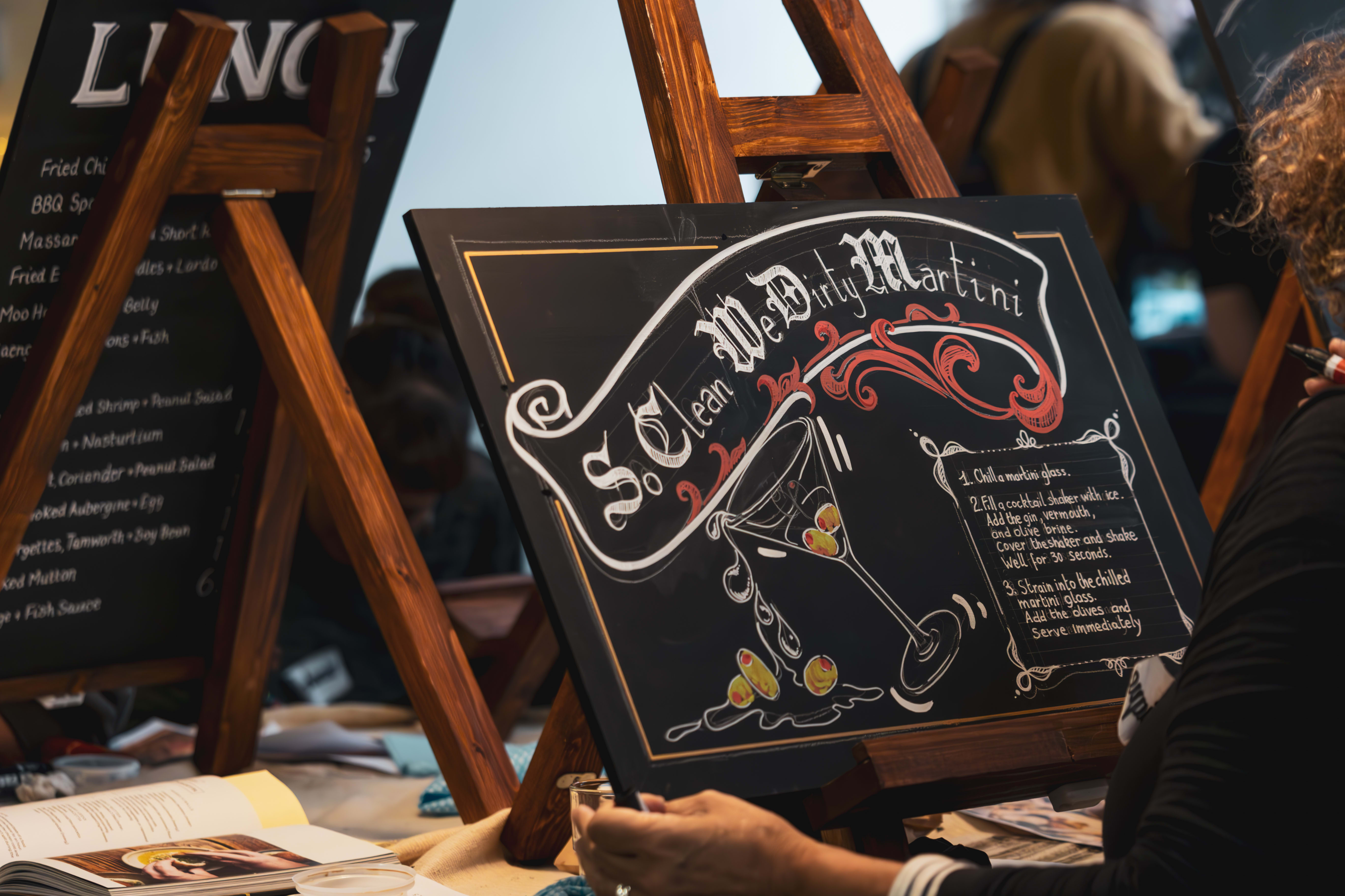 Decorated blackboard artwork with lettering and a cocktail illustration.