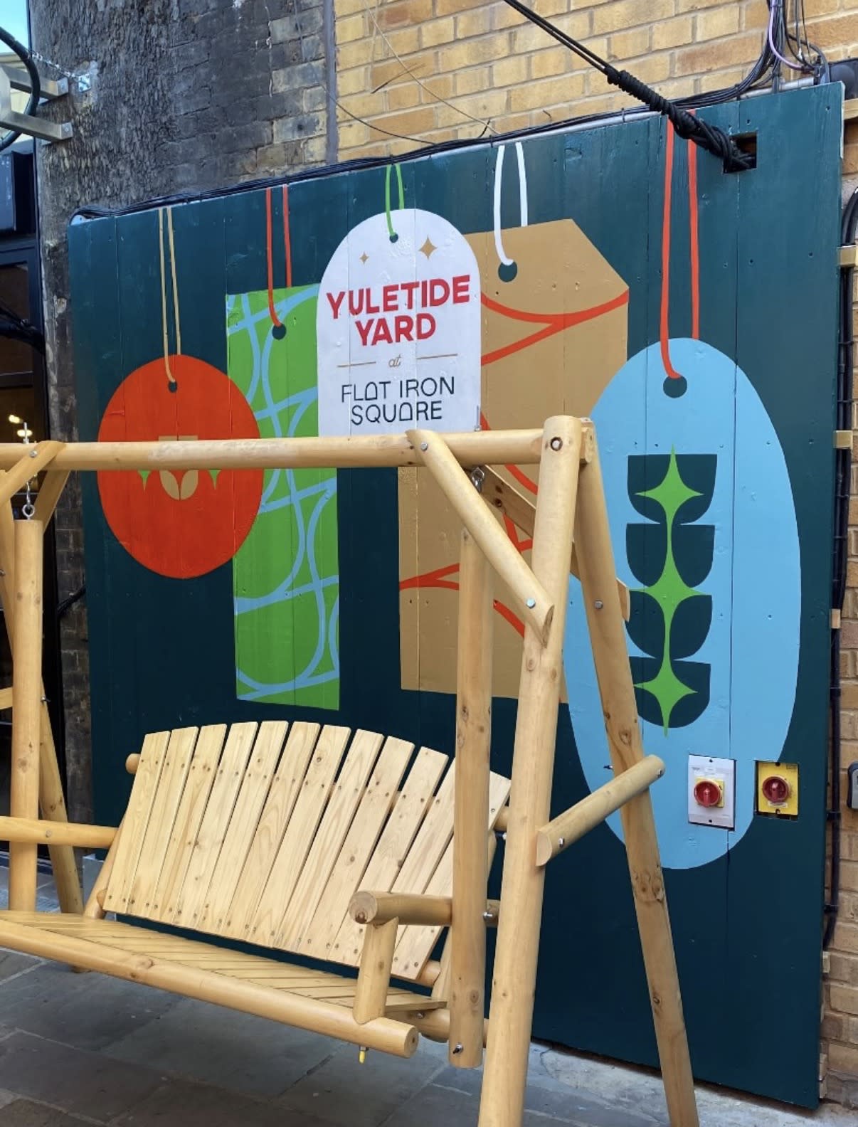 Colourful Yuletide Yard gift-tag mural at Flat Iron Square