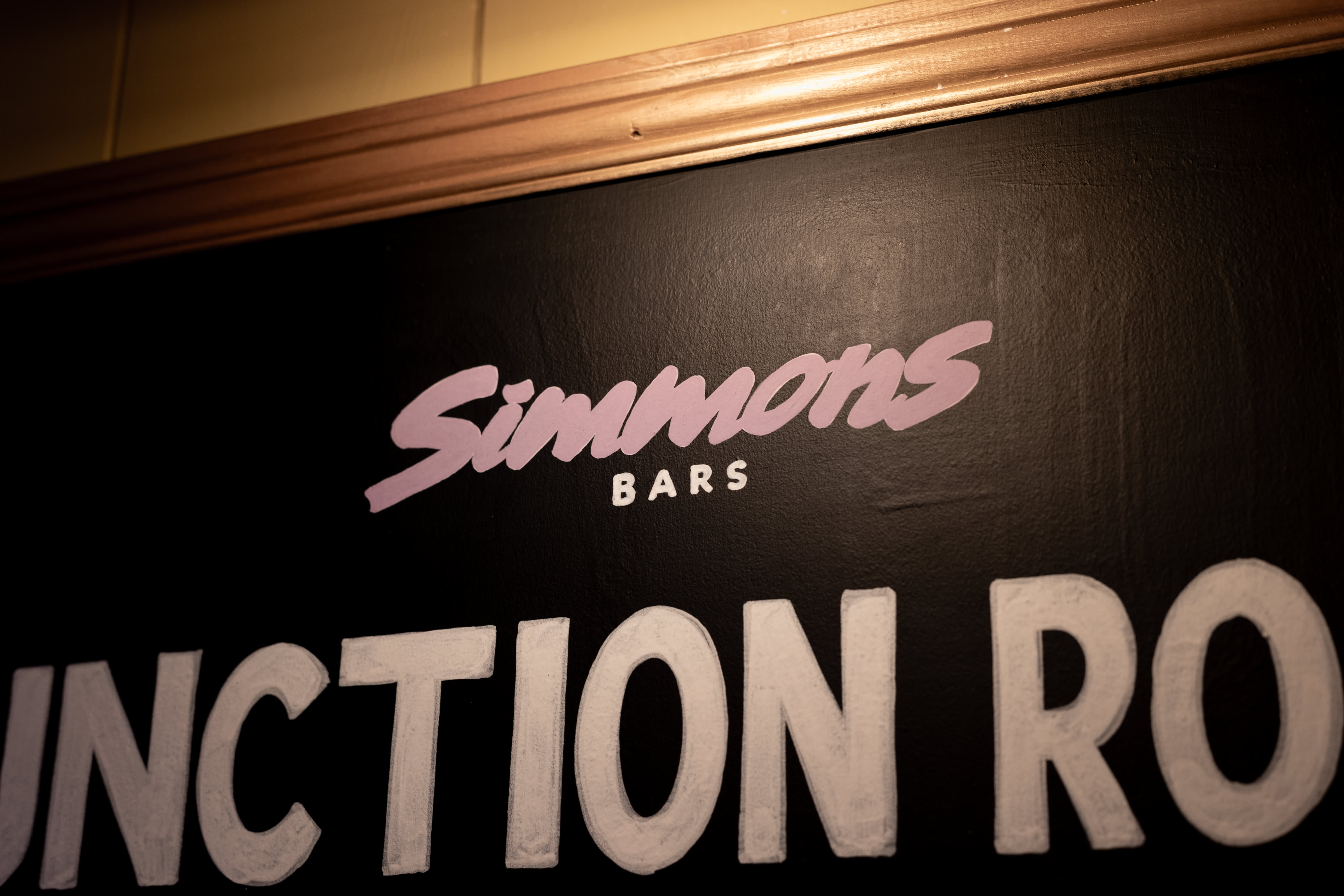 A close-up of Simmons Bars and Function Room lettering painted on a blackboard.