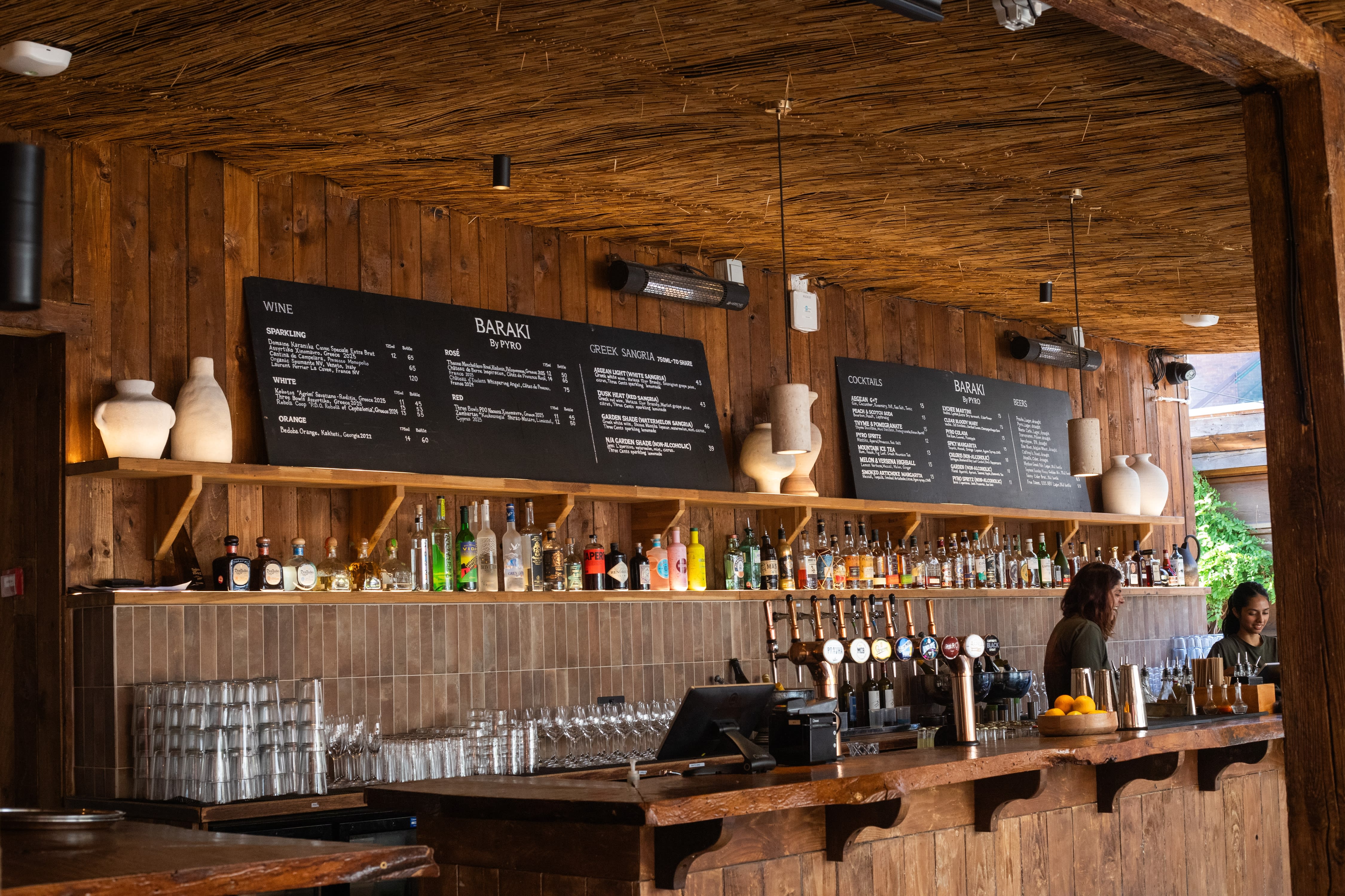 Hand-lettered blackboard menus above a timber-clad bar counter.
