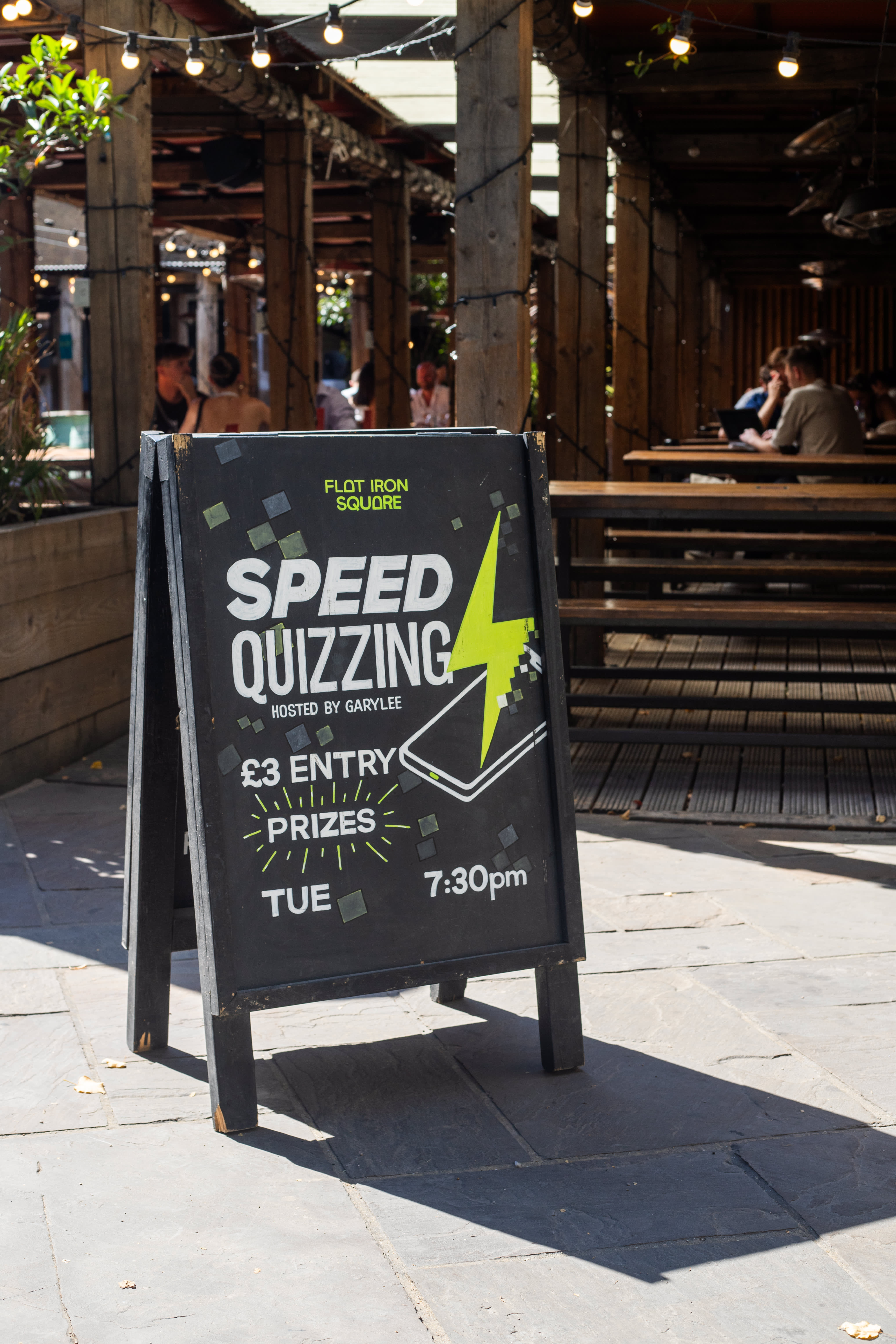 A hand-painted Speed Quizzing A-board outside Flat Iron Square.