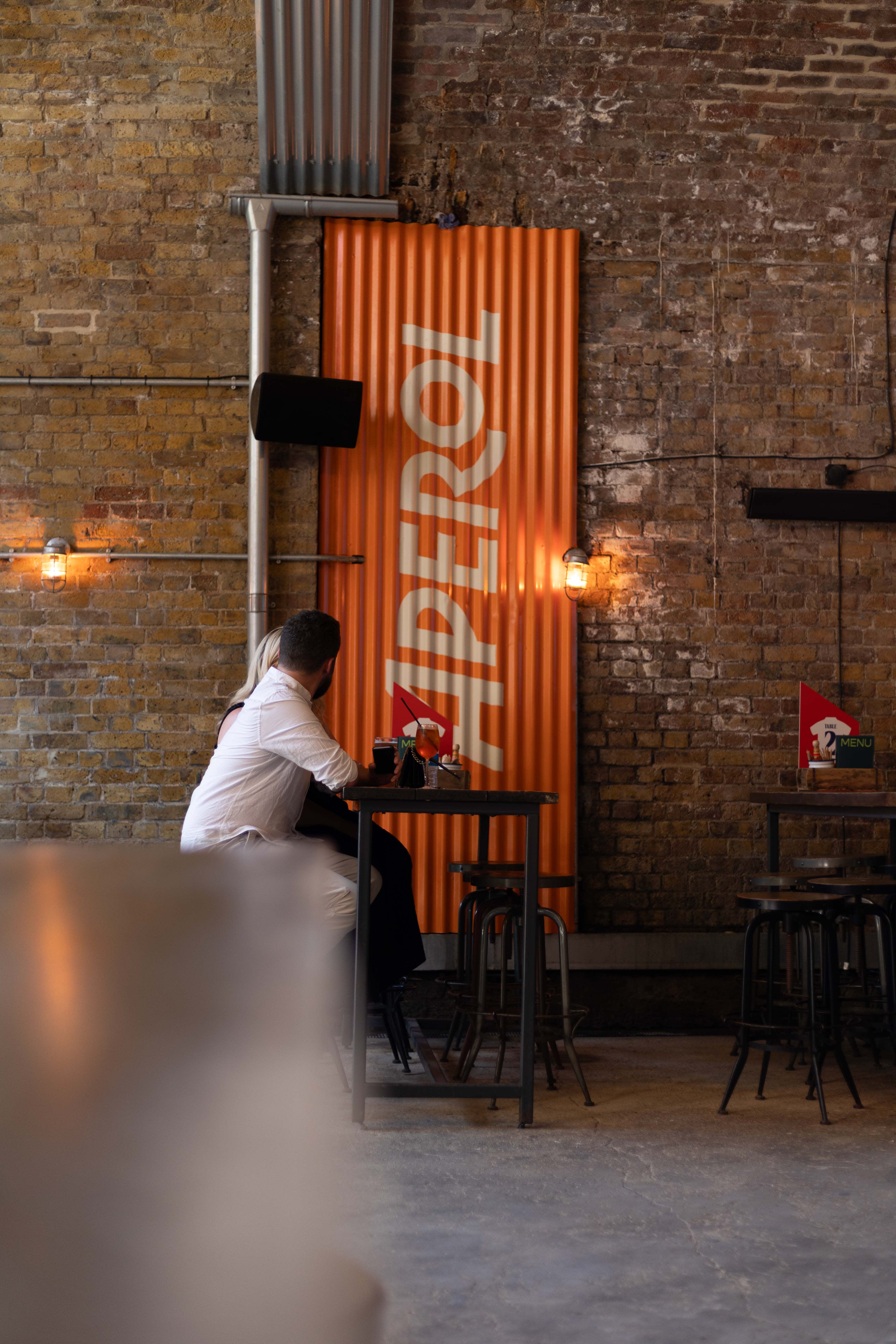 White Aperol lettering painted on an orange corrugated panel at Flat Iron Square.