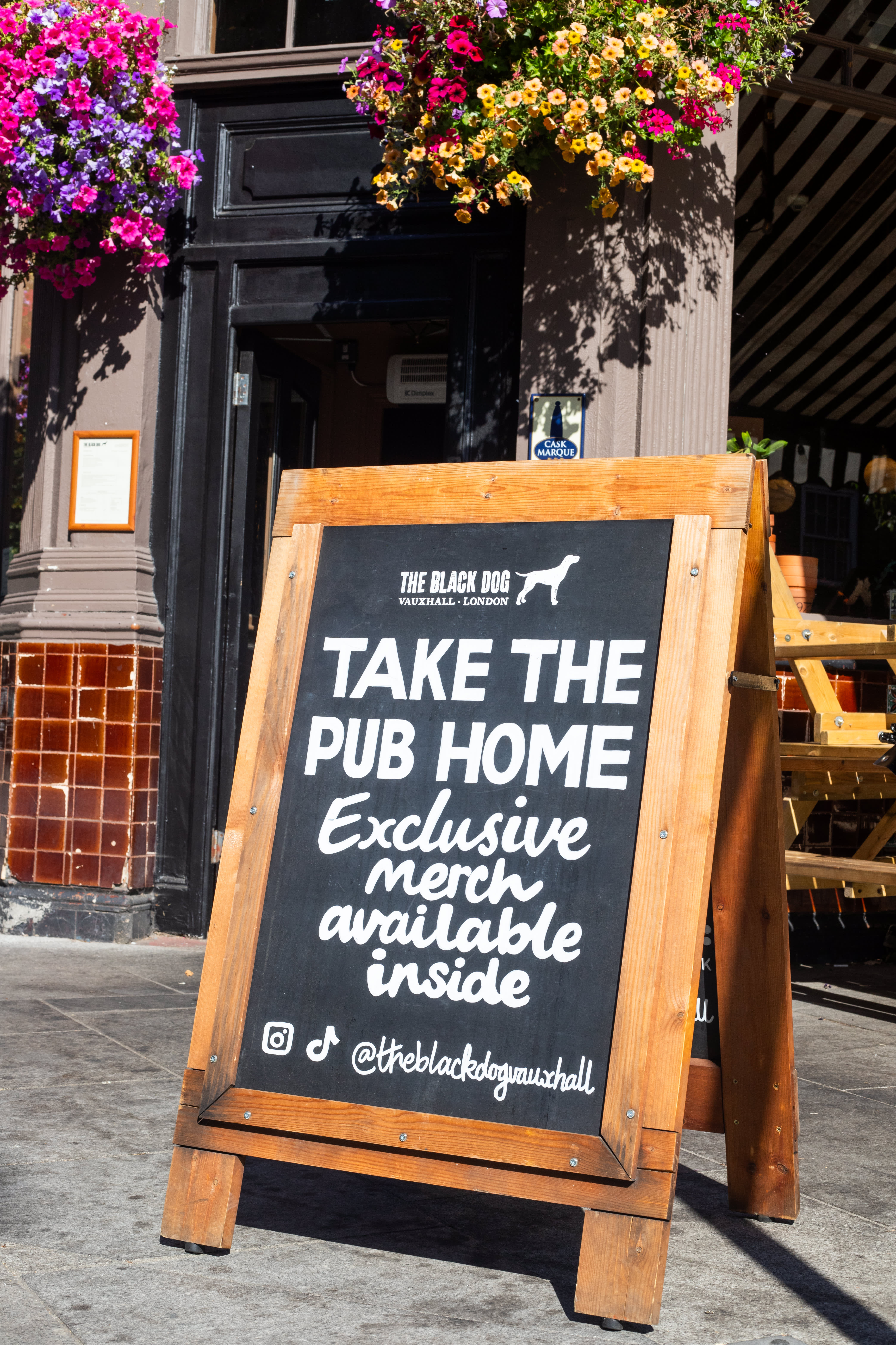 A hand-lettered Take the Pub Home merchandise A-board outside The Black Dog.