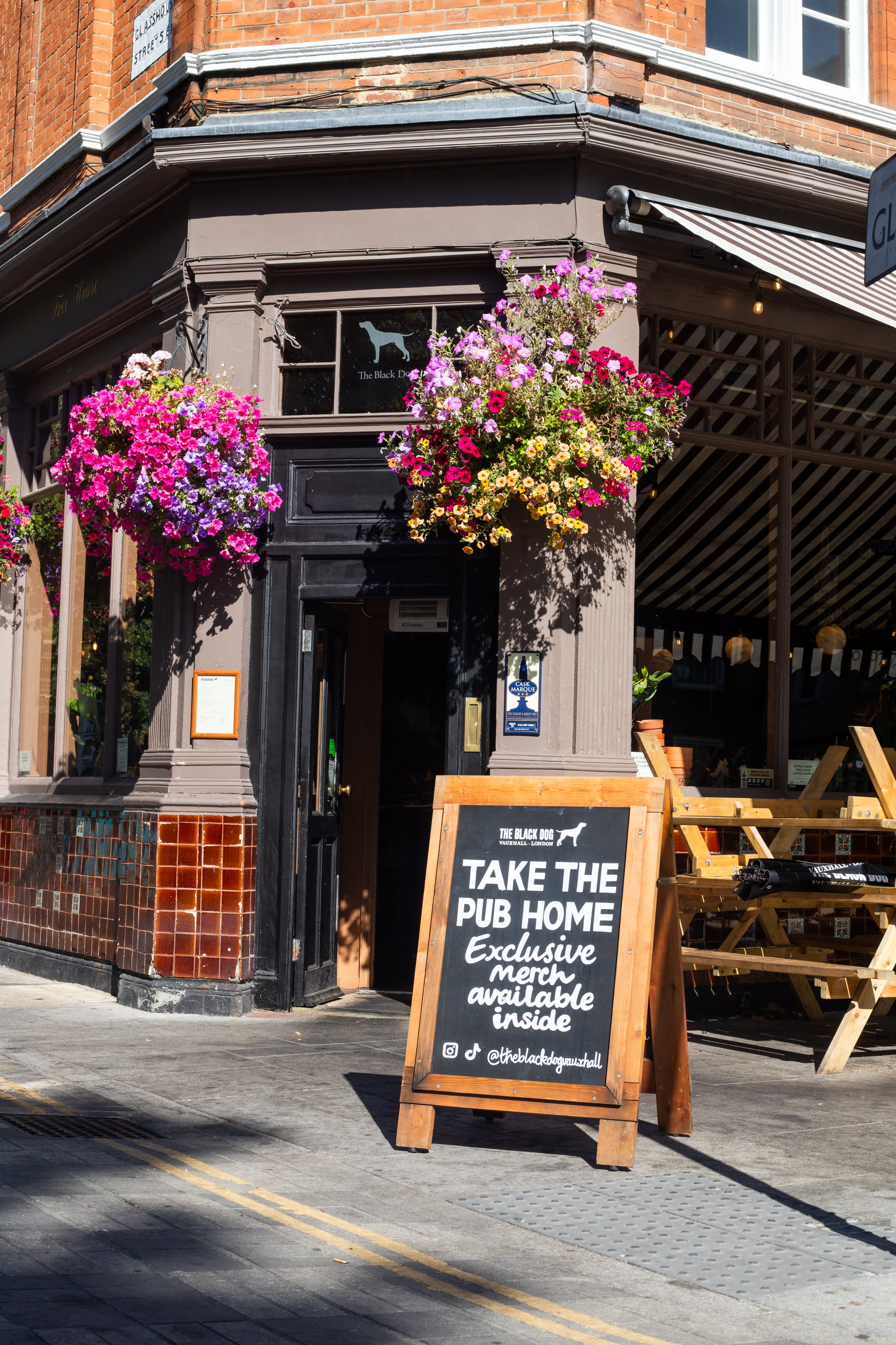 A hand-lettered merchandise A-board outside The Black Dog pub.