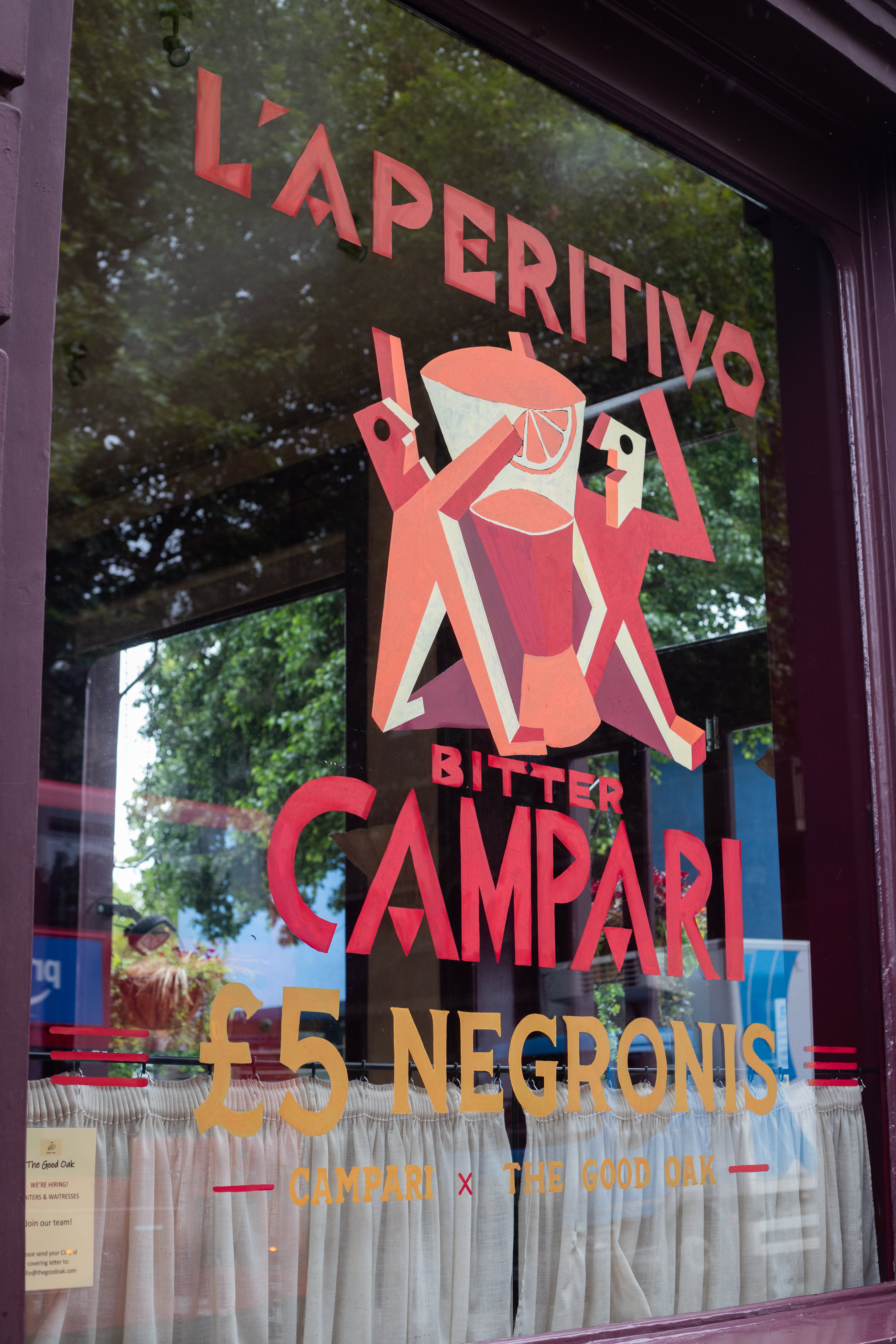 A hand-painted Campari Bitter aperitivo illustration and lettering on a pub window.