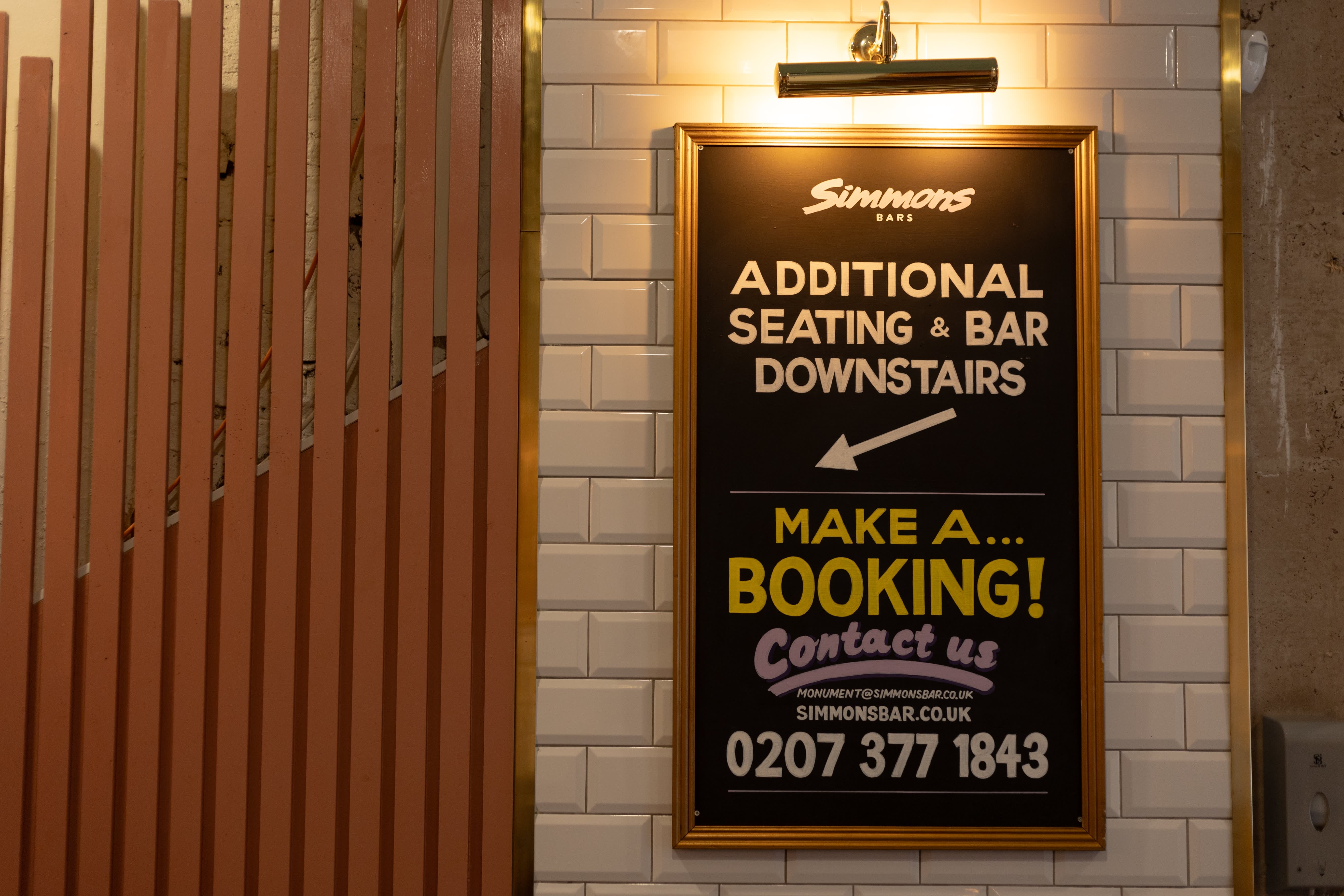 A Simmons blackboard directing guests to additional seating and the downstairs bar.